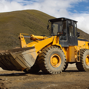 Construction equipment ready for pressure washing by First Priority Detail